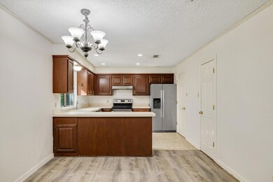 Kitchen featuring a chandelier, light wood-style f