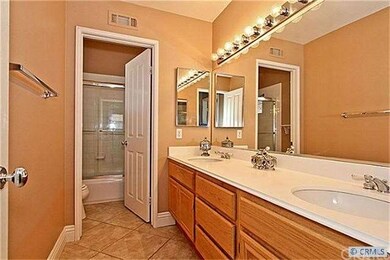 Roomy upstairs full bath with dual sinks, cabinets