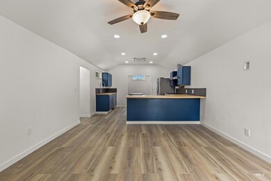 Kitchen featuring blue cabinets, lofted ceiling, a peninsula, ceiling fan, and recessed lighting