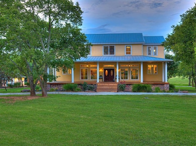 View of front of home featuring metal roof, a porc