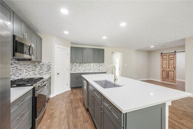 Kitchen with stainless steel appliances, gray cabi