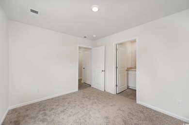 Unfurnished bedroom with light carpet and ensuite 