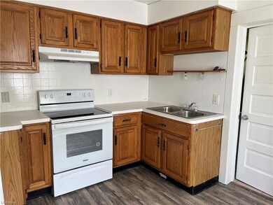 Kitchen with electric stove and wood cabinets