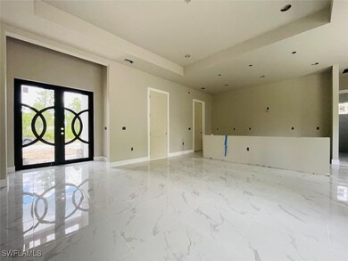 Empty room with a tray ceiling, french doors, base