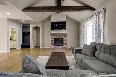 Living room with a brick fireplace, lofted ceiling