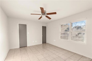 Unfurnished bedroom with a ceiling fan, light tile patterned floors, and a closet