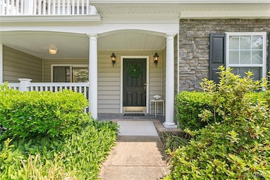 View of exterior entry with stone siding and a por