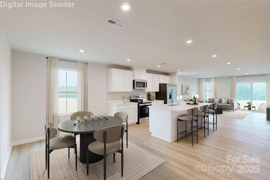 Sweeping panoramic views showcase the seamless flow from dining area to kitchen, into the expansive great room and out to the inviting back porch—capturing the heart of the home in one stunning frame.