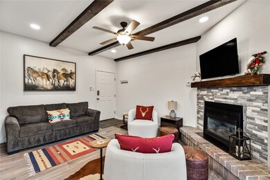Living room featuring ceiling fan, beamed ceiling,