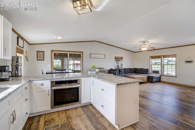 Kitchen featuring oven, ornamental molding, light 