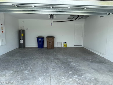 Garage featuring electric water heater and a garag