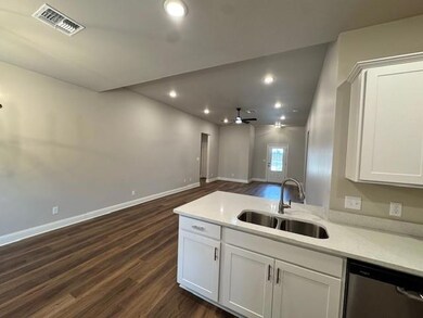 Kitchen with visible vents, white cabinets, open f