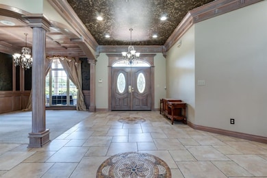 Tiled entrance foyer with a chandelier, crown mold