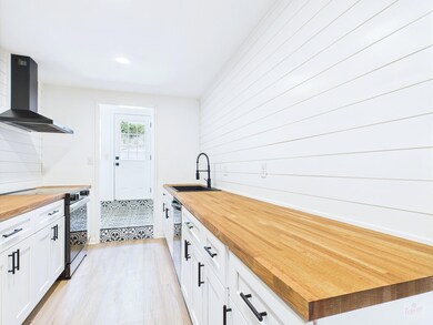 Kitchen with wood counters, wall chimney exhaust 