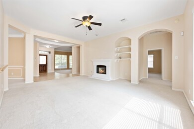 Open living room with gas log fireplace and built in shelving and tons of natural light. Living room currently prewired