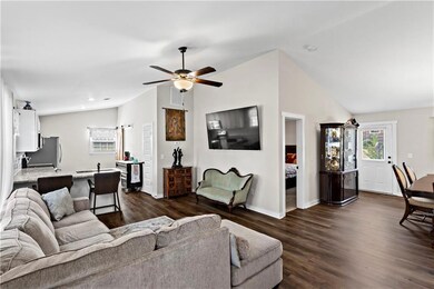Living area with lofted ceiling, dark wood-style f