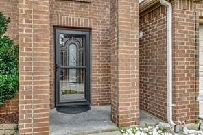 Doorway to property with brick siding