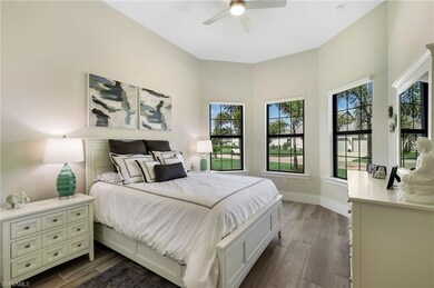 Bedroom featuring ceiling fan, multiple windows, and dark hardwood / wood-style floors