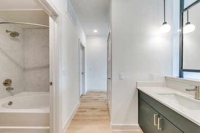 Bathroom with vanity, wood finished floors, and shower / bath combination