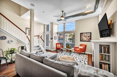 Living room featuring dark hardwood / wood-style floors, a high ceiling, and ceiling fan