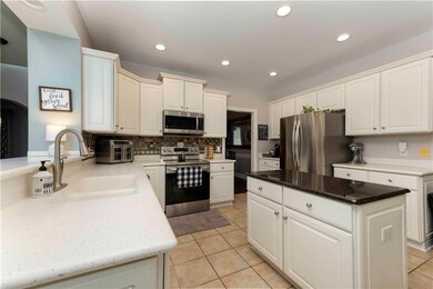 Kitchen featuring appliances with stainless steel finishes, tasteful backsplash, a kitchen island, light tile patterned floors, and recessed lighting