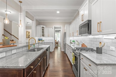 The chef’s kitchen is a showstopper—gas cooktop, updated tile backsplash, designer hardware and lighting, and stunning beams make it both functional and beautiful.