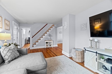 A cozy yet versatile living space-ideal for movie nights, playtime, or a home office setup, complete with classic wainscoting and warm hardwood floors.