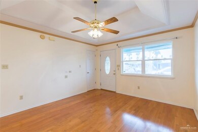 Living room with gorgeous hardwood floors.  View of front porch from double windows.  This home has electric storm shutters on the exterior that close up while away or in the event of a storm.