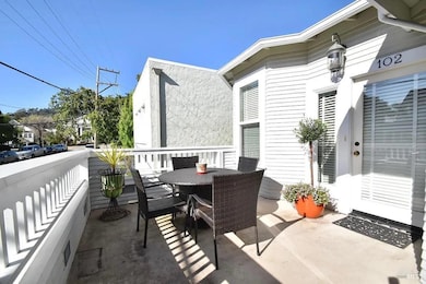At the top of the stairs, you'll find the entries for both Unit 102 and Unit 102A. The inviting outdoor dining area on the deck belongs to Unit 102 and overlooks vibrant F Street—just around the corner from popular restaurants and shops, including Th