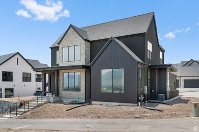 View of front of house featuring stone siding, a garage, roof with shingles, and driveway