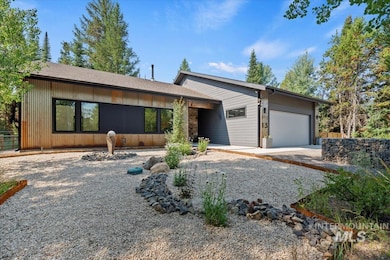 View of front of house with a garage, gravel driveway, and roof with shingles