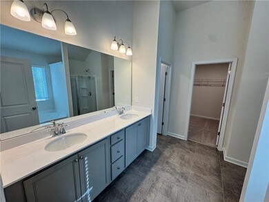 Full bath with a sink, baseboards, a stall shower,