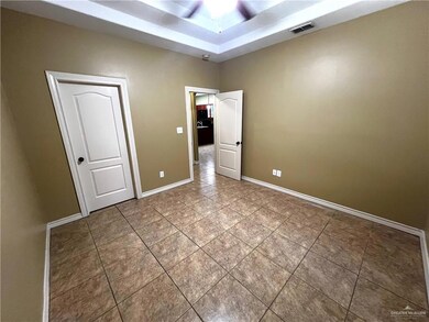 Unfurnished bedroom with tile patterned floors, baseboards, and a tray ceiling