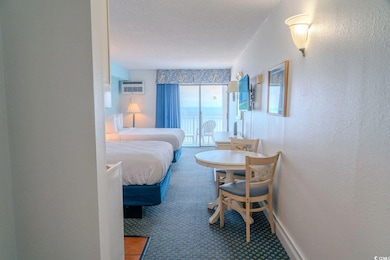 Bedroom with a textured wall, a wall mounted AC, carpet floors, and baseboards