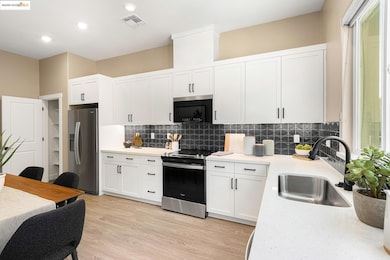 Kitchen with appliances with stainless steel finishes, light countertops, white cabinets, decorative backsplash, and recessed lighting