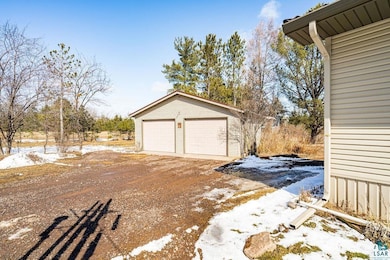 Snow covered garage with a detached garage