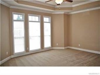 Master bedroom features boxed ceiling, natural lig