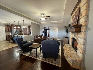 Living room featuring ceiling fan, a tray ceiling,
