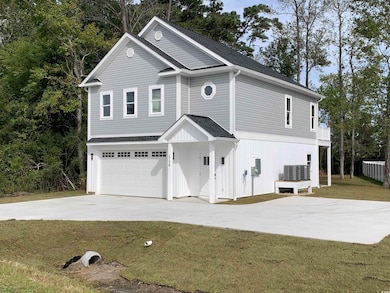 View of front of home featuring a garage, cooling 