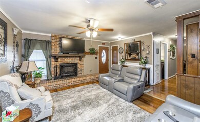 Living room featuring ceiling fan, a fireplace, or