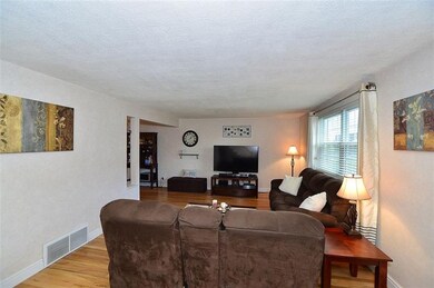 The spacious living room features gleaming hardwoo