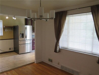 Diningroom view into Kitchen Freshly painted with contemporary chandelier