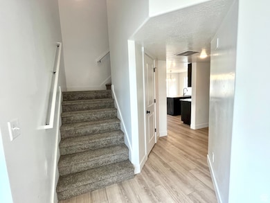 Stairway with wood finished floors and baseboards