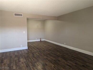 Spare room featuring dark wood-style floors, a tex
