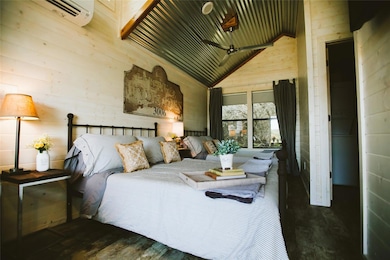 Bedroom with a wall mounted air conditioner, wood