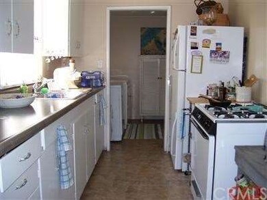 Galley kitchen in front house. Can see laundry roo