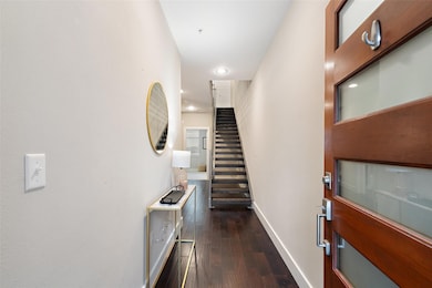 Foyer featuring dark wood-style flooring, baseboa