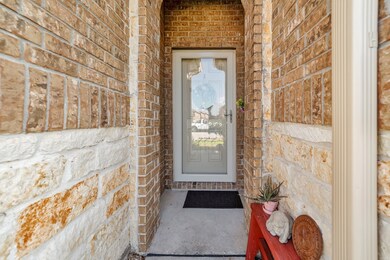 Beautiful stone and brick entry with storm screen door.