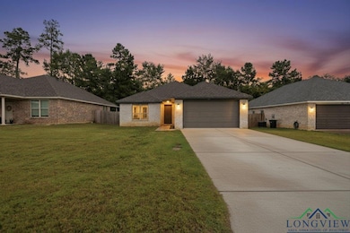 View of front of home featuring driveway, brick siding, and an attached garage