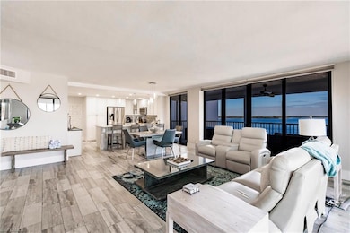 Living room featuring ceiling fan, a water view, a